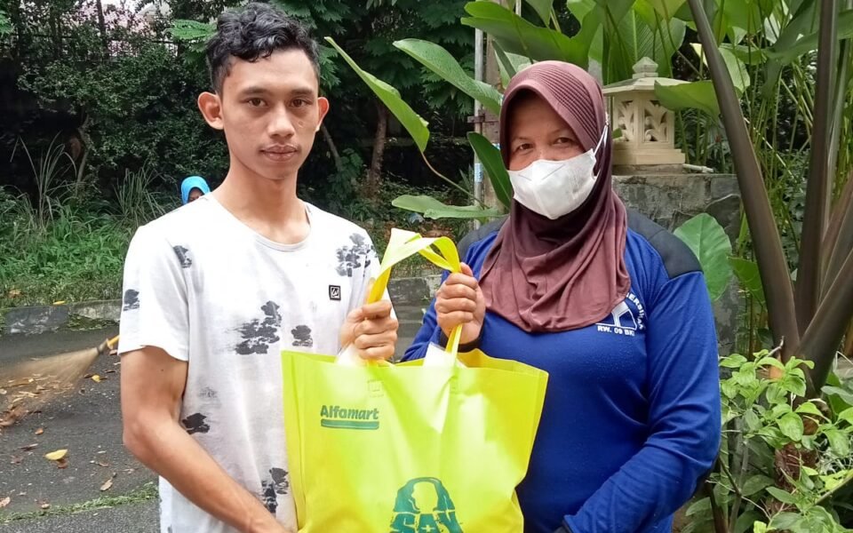 Relawan menyerahkan paket Sedekah Subuh kepada warga penerima manfaat